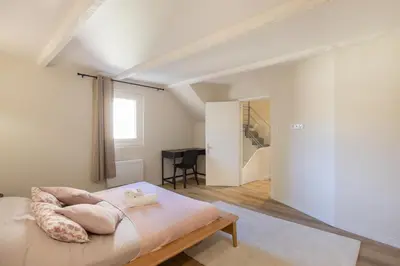a bedroom with a bed with pillows on it at L'antiquaire - 3 chambres - Hypercentre - Wifi in LʼIsle-sur-la-Sorgue