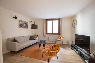 a living room with a couch and a tv at L'antiquaire - 3 chambres - Hypercentre - Wifi in LʼIsle-sur-la-Sorgue