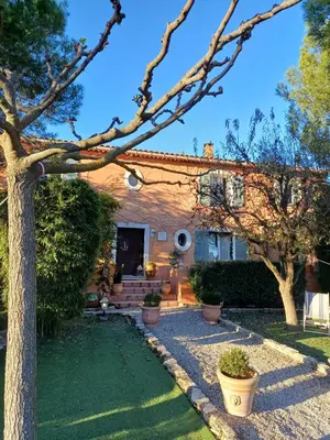 a house with a tree in the yard at Chambre d'hôte suite Tournesol 