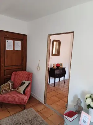 a room with a chair and a mirror and a table at Chambre d'hôte suite Tournesol 
