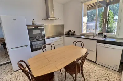 a kitchen with a wooden table and chairs in it at Maison de caractère au coeur de la Provence in Mallemort