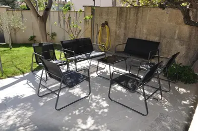 three black chairs and a table in a yard at Maison de caractère au coeur de la Provence in Mallemort