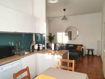 a kitchen with white cabinets and a living room at Villa Tassigny in Aix-en-Provence