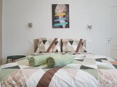 a bed with two pillows and a picture on the wall at Villa Tassigny in Aix-en-Provence