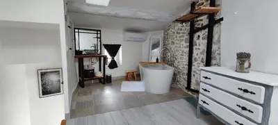 a bathroom with a tub and a sink and a dresser at Latipik in Lançon-Provence