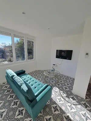 a living room with a blue couch and a flat screen tv at La Petite Maison des Boettes in Carpentras