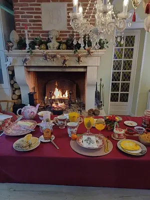 a table with plates of food and a fireplace at Chambre d hôte gite Au fond du jardin in Saint-Saturnin-lès-Avignon