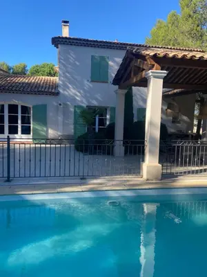 a house and a swimming pool in front of a fence at Maison de Golfeur in Mallemort