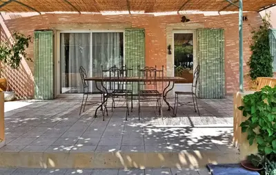a patio with a table and chairs on it at La Villa Des Songes in Pernes-les-Fontaines