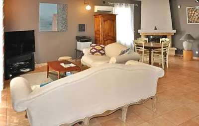 a living room with a couch and a table at La Villa Des Songes in Pernes-les-Fontaines