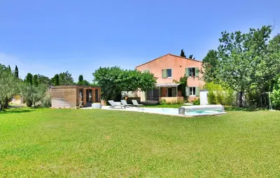 a large yard with a house and a pool at La Villa Des Songes in Pernes-les-Fontaines