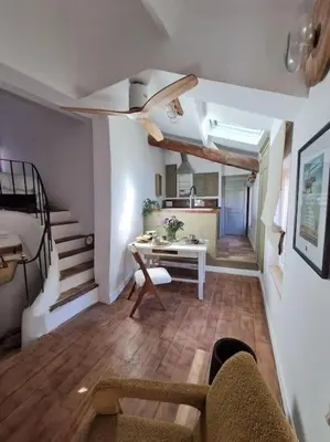 a living room with a couch and a table and a bed at Appartement avec terrasse sur les toits classé 5* in LʼIsle-sur-la-Sorgue