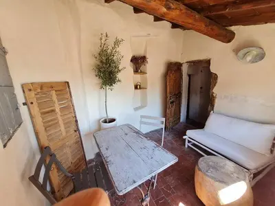 a living room with a table and a couch at Appartement avec terrasse sur les toits classé 5* in LʼIsle-sur-la-Sorgue