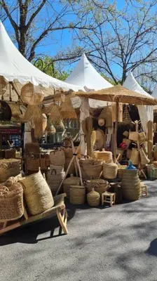 a market with baskets and umbrellas on the street at Appartement avec terrasse sur les toits classé 5* in LʼIsle-sur-la-Sorgue