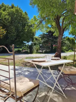 a table and two chairs sitting next to a tree at Le Mas du Castellas 5* in Le Thor