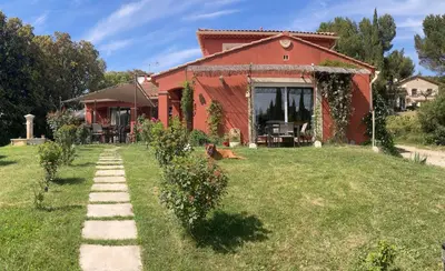 a house with a dog laying in the yard at Domaine des Lavarines in Morières-lès-Avignon