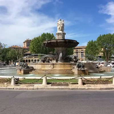 a fountain with a statue in the middle of a street at Terrasse & Spa dans Aix Hypercentre in Aix-en-Provence