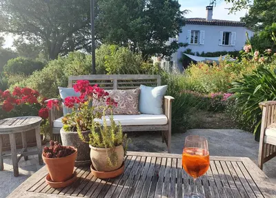 a patio with a couch and a table with flowers at Lou Pantai, Bed and breakfast, small double Bedroom in Aix-en-Provence