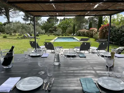 a table with glasses and plates and a bottle of wine at Lou Pantai, Bed and breakfast, small double Bedroom in Aix-en-Provence