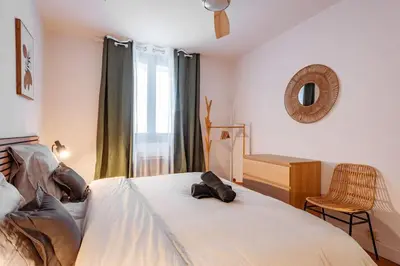 a bedroom with a bed and a chair and a window at CŒUR DU VENTOUX Carpentras Bel appart 6 places in Carpentras