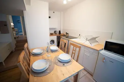 a kitchen with a wooden table with plates on it at L'évasion de Bedoin, appartement in Bédoin