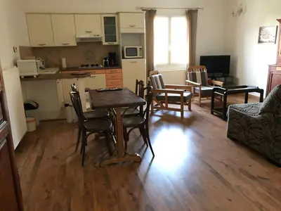 a living room with a table and chairs and a kitchen at Charmant T2 2/4 Personnes in Pernes-les-Fontaines