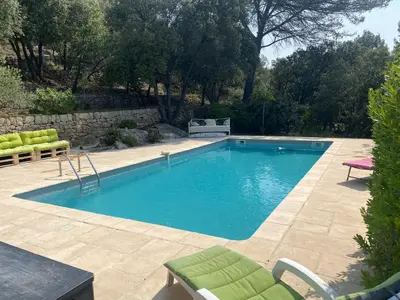 a swimming pool in a yard with chairs and a table at LA BASTIDETTE PROVENçALE in Jouques