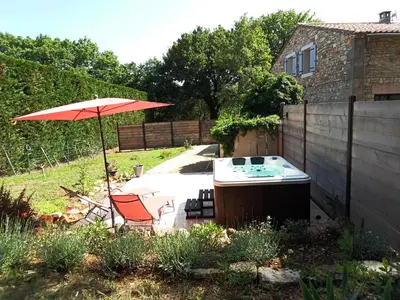 a garden with an umbrella and a sink and a chair at Appartement en campagne au coeur du luberon in Roussillon