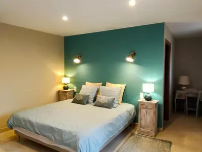 a bedroom with a bed with a blue wall at Le mas de Roussillon in Roussillon