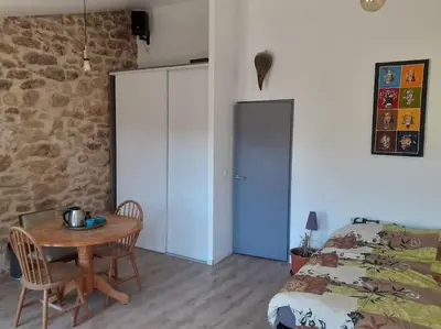 a bedroom with a table and a bed and a table and chairs at Maison restaurée à l'ancienne avec terrasse in Jouques