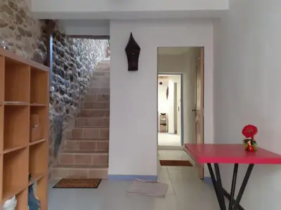 a room with a red table and a staircase at Maison restaurée à l'ancienne avec terrasse in Jouques