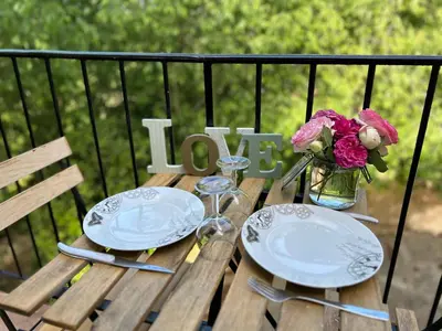 a wooden table with two plates and a vase of flowers at Appartement cosy in Aix-en-Provence