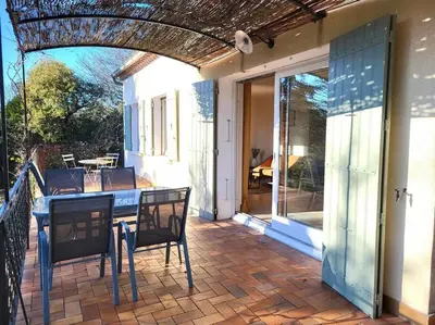 a patio with a table and chairs on a house at Maison avec piscine chauffée, centre village in Saint-Saturnin-les-Apt