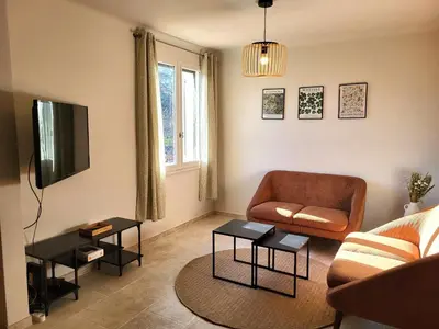 a living room with a couch and a television at Maison avec piscine chauffée, centre village in Saint-Saturnin-les-Apt