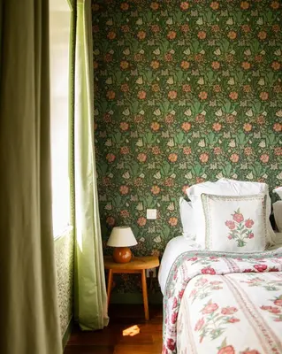 a bedroom with a bed and a floral wall at Le Clos de Gordes in Gordes
