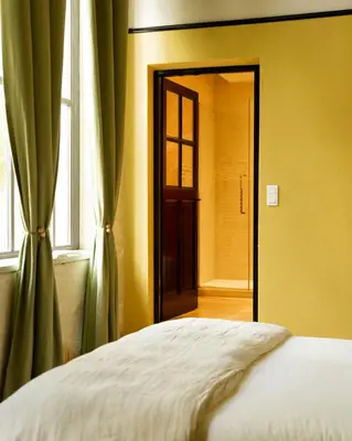 a bedroom with a bed and a window and a door at Le Clos de Gordes in Gordes