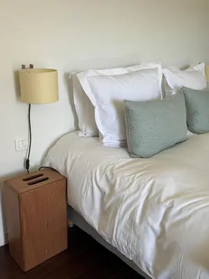 a bed with white pillows and a table with a lamp at Le Clos de Gordes in Gordes