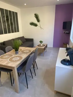 a living room with a table and a couch at Escapades L'Isloises au cœur de L'Isle-sur-la-Sorgue. in LʼIsle-sur-la-Sorgue