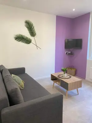 a living room with a couch and a table at Escapades L'Isloises au cœur de L'Isle-sur-la-Sorgue. in LʼIsle-sur-la-Sorgue