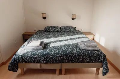 a bedroom with a bed with a green comforter at La ferme du 645 in Entraigues-sur-la-Sorgue
