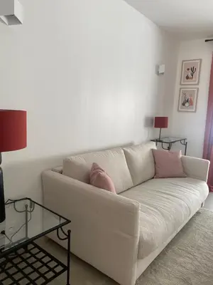 a white couch in a living room with a table at Gîte cosy et tout équipé 