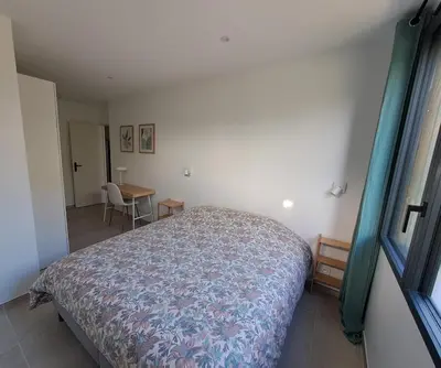 a small bedroom with a bed and a table at Gîte cosy et tout équipé 
