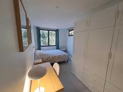 a bedroom with a bed and a table in a room at Gîte cosy et tout équipé 