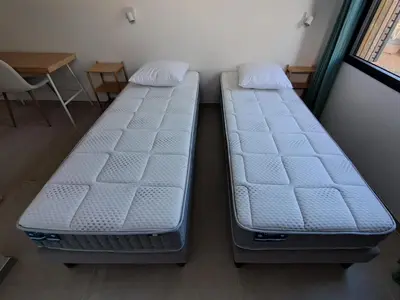 two beds sitting next to each other in a room at Gîte cosy et tout équipé 