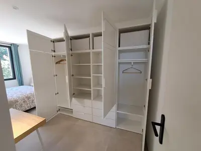 a white closet with white shelves in a room at Gîte cosy et tout équipé 