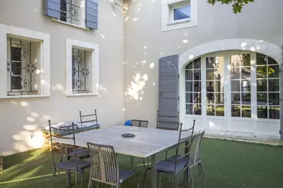 a table and chairs in front of a building at Le Petit Mas Rey in Eyragues