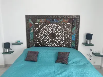 a bed with a head board with two pillows on it at House of Essia in Aix-en-Provence