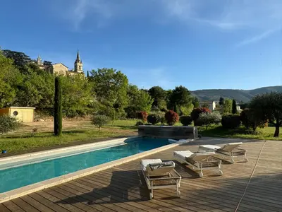 a swimming pool with lounge chairs and a house at Maison d’Oléa in Bonnieux