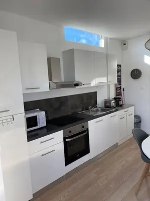 a white kitchen with a sink and a microwave at 