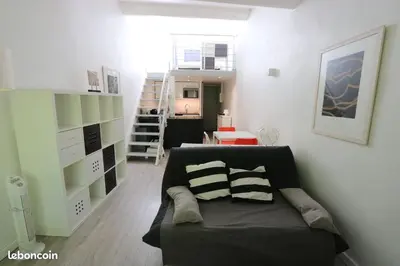a living room with a couch and a stair case at Le Gassendi Duplex in Aix-en-Provence